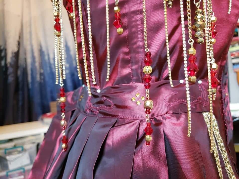 The sash of the Smaug cosplay dress has Tolkien's own sketch of Smaug embroidered onto it. We also see rhinestones and beads hanging from the shoulders of the dress.