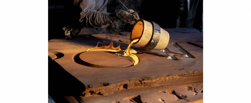 A close up of the crucible from with the molten metal is being poured, into the O of POWER