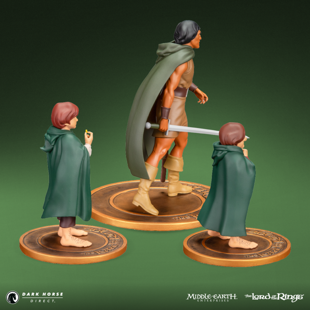 Three Lord of the Rings action figures on circular bases: a tall warrior with cape and sword, flanked by two cloaked hobbits.
