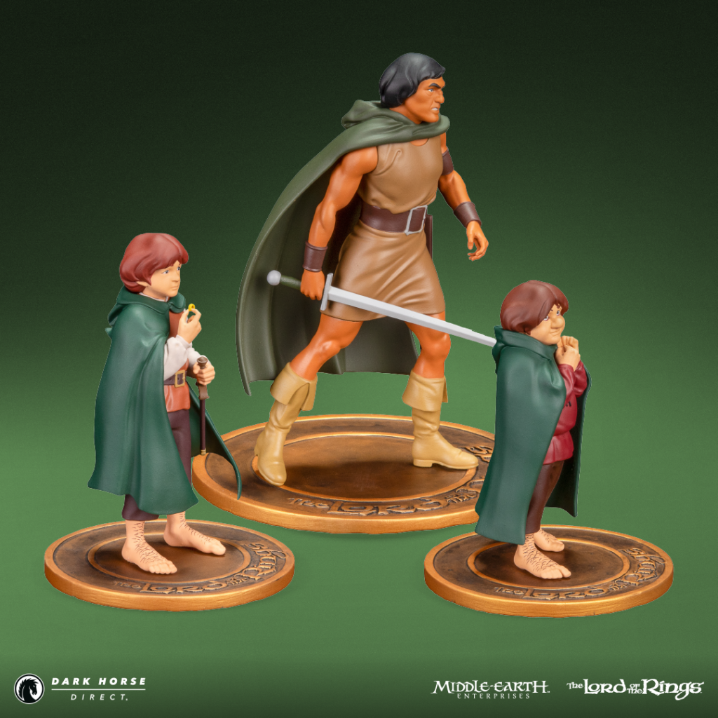 The Lord of the Rings action figure set: a warrior with cape and sword flanked by two hobbits in green cloaks on round bases.
