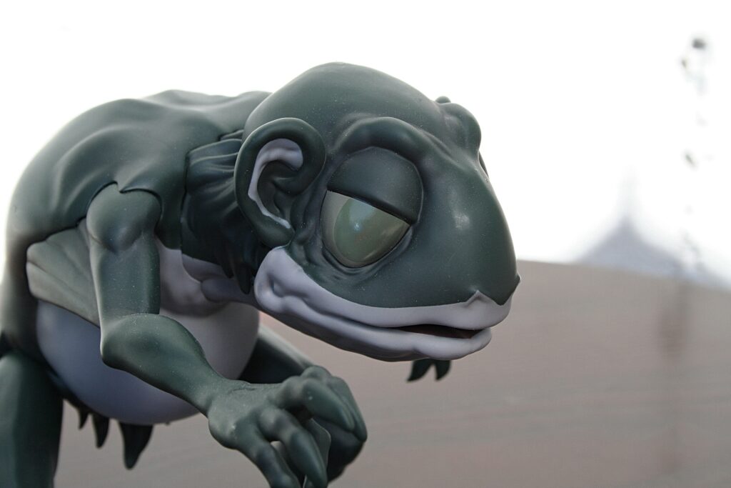 Close-up of a dark green dragon figurine focusing on its head and curled clawed limb