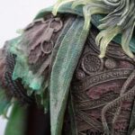 Close-up of weathered bronze armor plates with green patina and intricate engravings.