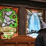 Stained-glass panel reading 'The Prancing Pony' with a white unicorn holding a beer mug, inside a wooden frame.