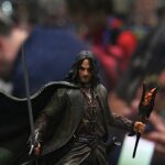 Action figure of a long-haired fantasy warrior in a dark leather outfit and cape, wielding a sword.