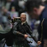 Elven archer figurine in dark armor, drawn bow ready for attack.