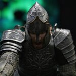 Close-up of a medieval knight in ornate, dark metal armor with a pointed helmet and decorative engravings, mid-action pose against a dark background.