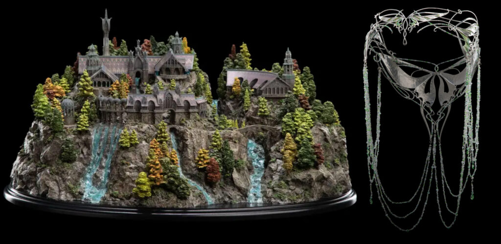 Detailed miniature mountain fortress scene with trees, a waterfall, and rocky base beside an ornate silver mask with beaded chains.