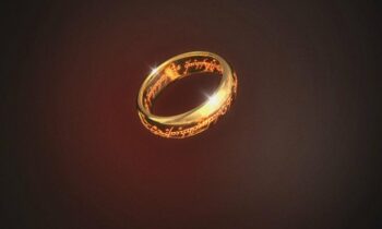 Glowing gold ring with fiery inscriptions hovering in a dark red background.